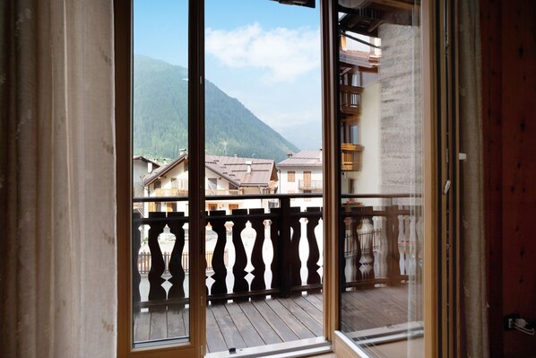 Un balcon avec vue sur une montagne et des bâtiments.