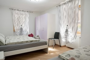 Une chambre à coucher avec un lit, une chaise, une armoire et un radiateur.