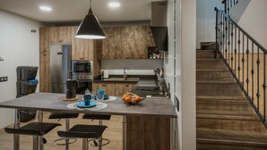 Una cocina moderna con una isla central, electrodomésticos de acero inoxidable y un revestimiento de pared de madera.
