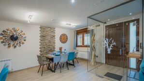 Un comedor moderno con una mesa redonda, sillas y un elemento decorativo en la pared.