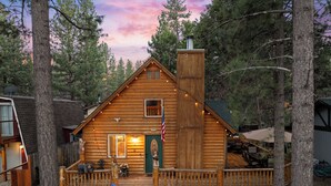 Una baita di legno con un portico, un camino e una bandiera americana.