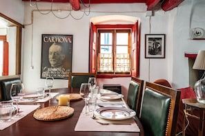 A dining table set with plates, glasses, and cutlery, a candle, and a poster on the wall. - Holiday Home 'Casa Do Pelourinho' with Private Terrace and Wi-Fi (Avis)
