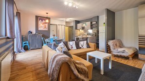 Una sala de estar moderna con un sofá, una mesa de centro y un comedor con sillas.