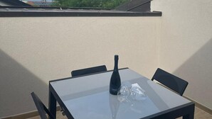 Una mesa con sillas en un balcón con vistas a montañas y un lago.