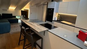 Una cocina moderna con tragaluz, suelo de madera y una zona de comedor con mesa y sillas.