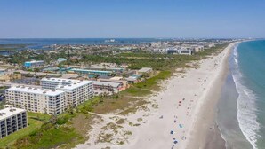 Eine Küstenstadt mit Strand, Gebäuden und blauem Himmel.