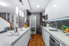 Une cuisine moderne dotée d’un îlot central, d’un four encastré et d’un four à micro-ondes.