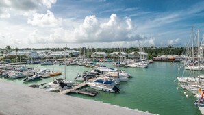 A marina with numerous boats docked, a clear sky, and buildings in the background. - Honoré apartment with views of the marina and golf course 2mn from beaches (Saint-François)