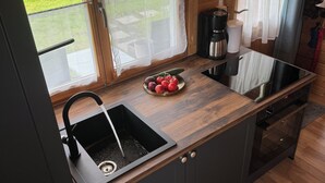 A compact kitchen with a wooden countertop, a sink, and a coffee maker. - Cozy I Log cabin in the Bavarian Forest I National Park (Neureichenau)