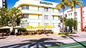 Ein BarBizon Hotel mit Außenbereich und Palmen.