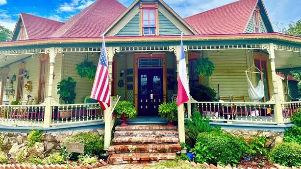 A two-story house with a porch, a front door, and a small brick staircase leading to the entrance. - Irishette (Dublin)