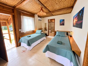 A room with two beds, a wooden ceiling, a window with curtains, a door, and a wall with a picture. - Tahaa Pousada Boutique (Ilhabela)