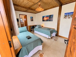 Una habitación con dos camas, un escritorio y una silla.