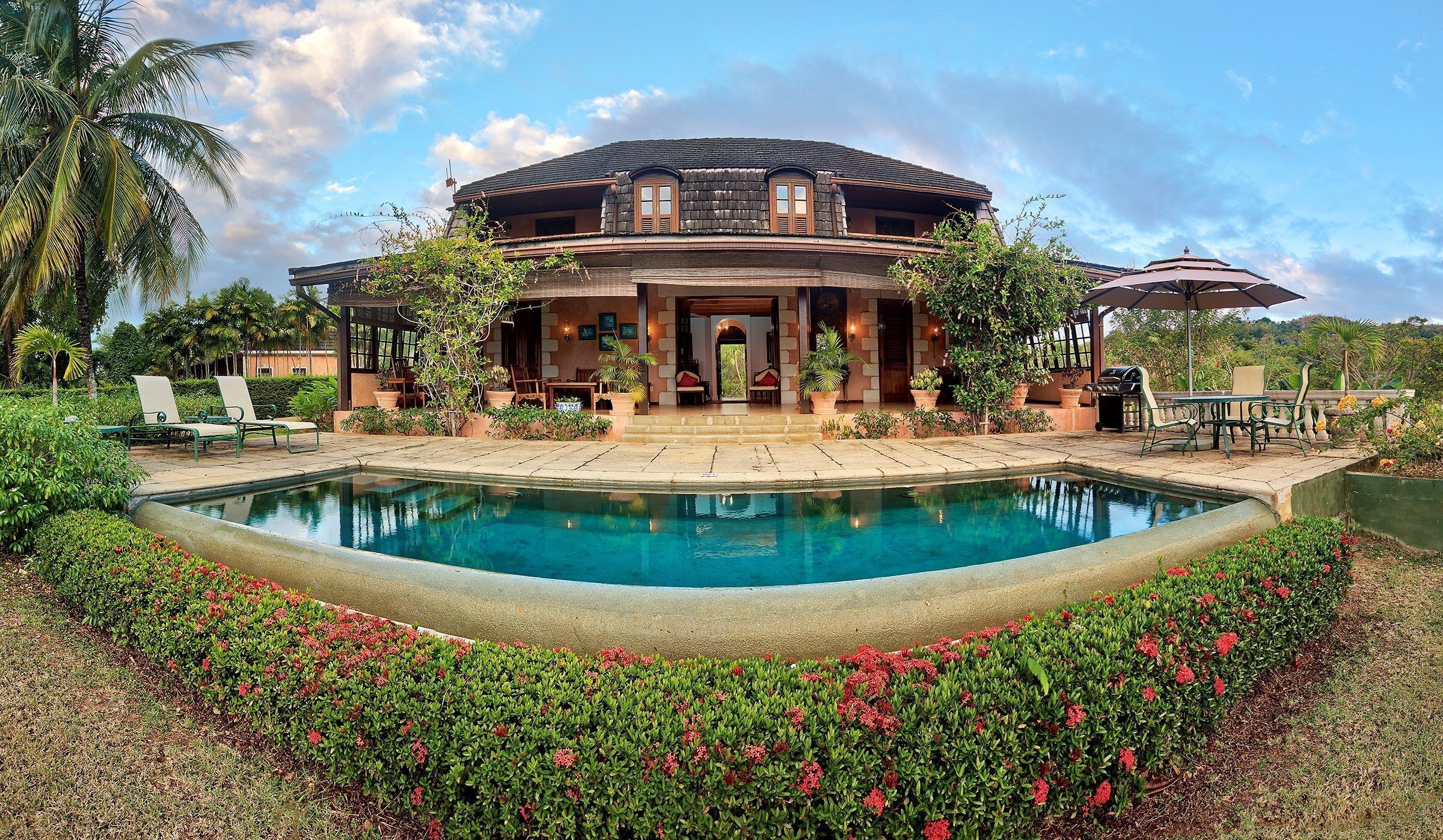 A large, circular building with a pool in front.