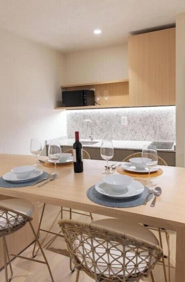 Enjoy a romantic dinner for two at this stylish dining area, complete with a wine bottle and glasses.