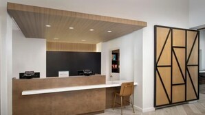 A reception desk with a modern design, a seating area, and a decorative wall panel.