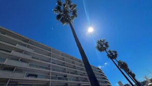 A multi-story hotel with a modern architectural design, featuring balconies and large windows.