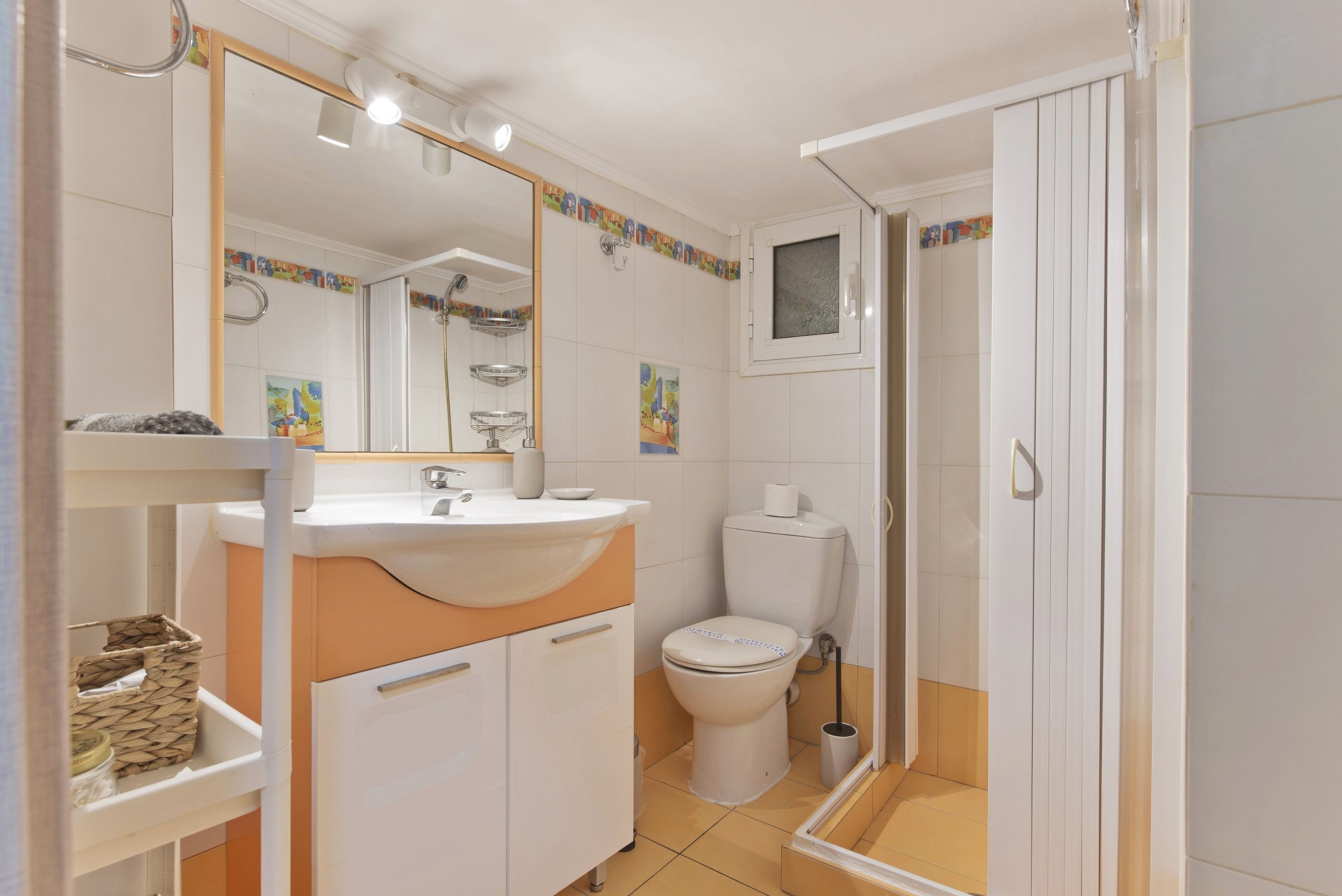 Une salle de bain avec un lavabo blanc, un miroir et des toilettes.