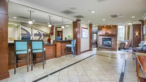 A lobby with a reception desk, seating area, and a fireplace.
