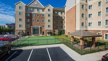 A multi-story hotel with a brick facade, a green lawn, and a gazebo.