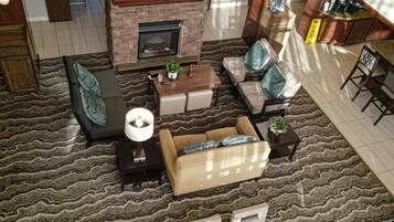 A modern living room with a fireplace, seating area, and a television mounted above it.