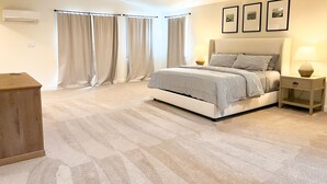 A bedroom with a bed, bedside tables, a ceiling fan, and curtains. - Elevated Eugene Retreat: Bright, Calm & Spacious (Eugene)