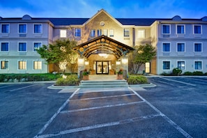 A multi-story hotel with a central entrance, a covered waiting area, and a parking lot. - Free Breakfast. Pool & Hot Tub. Near East Towne Mall! (Madison)