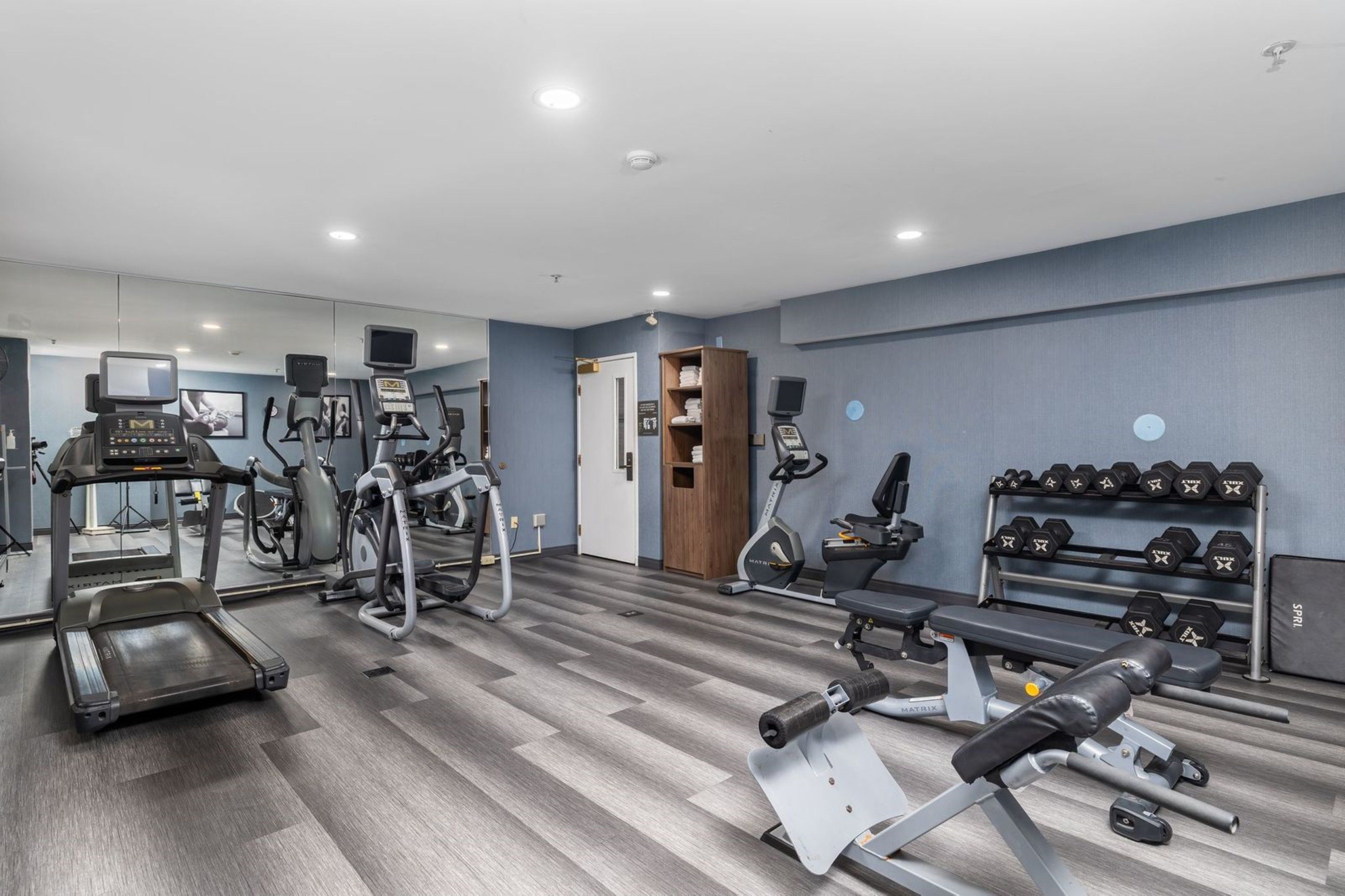 A gym with treadmills, elliptical machines, and weight equipment.