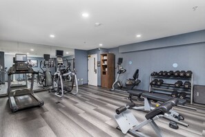 Ein Fitnessstudio mit Laufbändern, Crosstrainern und Gewichtsmaschinen.