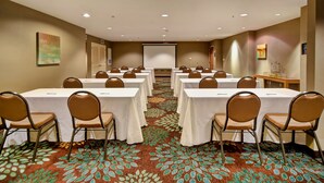 A conference room with multiple tables and chairs, a projector screen, and a carpeted floor. - Free Breakfast. Pool & Hot Tub. Near East Towne Mall! (Madison)