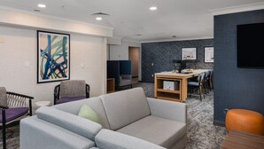 A modern hotel room with a sofa, a dining table with chairs, and artwork on the walls. - Free Breakfast. Pool & Hot Tub. Near East Towne Mall! (Madison)