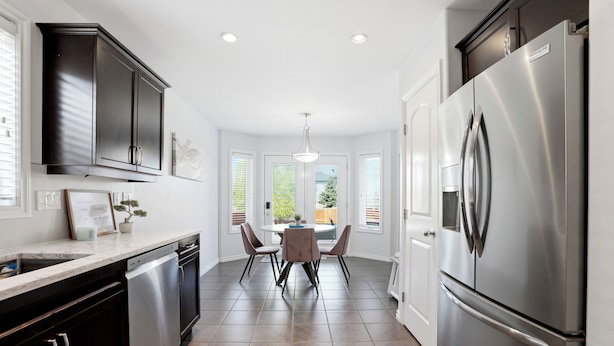 A modern kitchen with a dishwasher, double sink, and stainless steel refrigerator. - Spacious 4BR-4BA House for Large Families & Group in Stonebridge (Saskatoon)