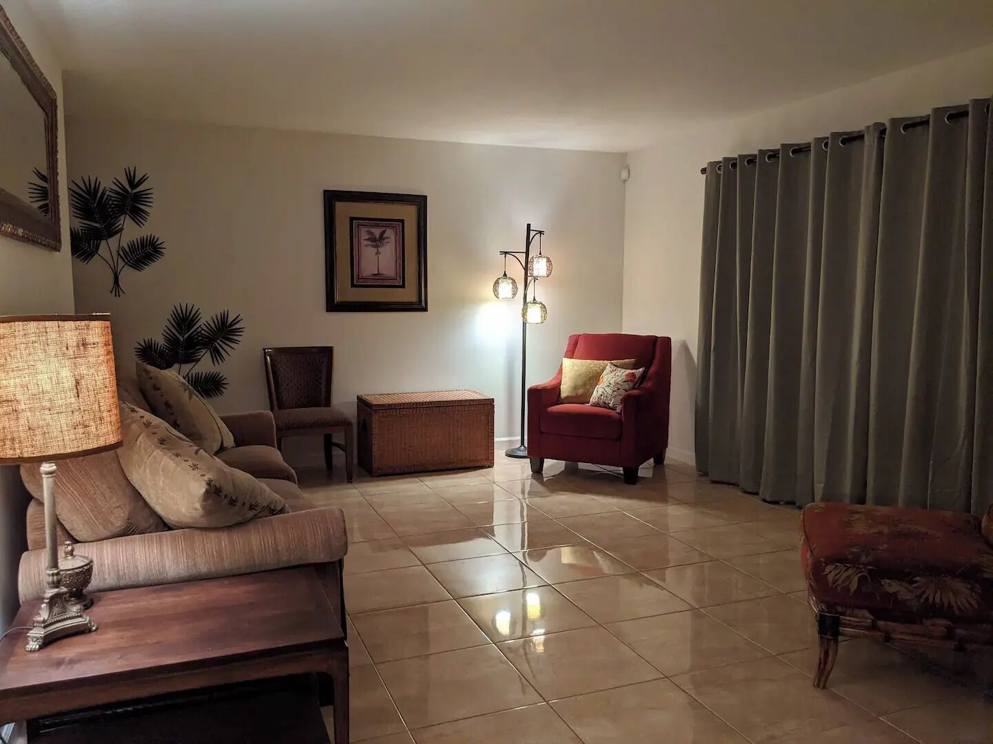A living room with a sofa, armchair, and a floor lamp.