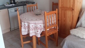 A compact kitchen with a dining table, chairs, a microwave, a coffee maker, and a cabinet. - Maison et Loisirs (Calvisson)