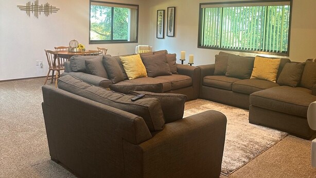 A spacious living room with a high ceiling, skylight, and large windows. - The Sequim Tree House is a spacious one bedroom with a bonus room for more guest (Sequim)