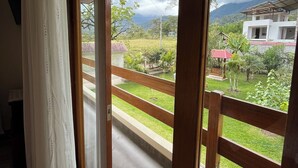 A room with a sliding glass door leading to a balcony with a view of a residential area and a mountain. - Casa Oxapampa (Oxapampa)