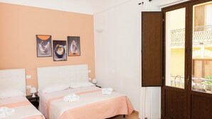 A hotel room with two beds, a wooden door, and a balcony with a metal railing. - Room 2 A (Trapani)