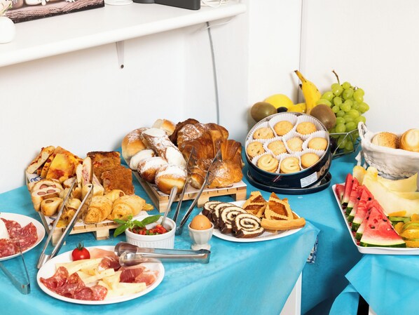 A table with various food items including pastries, meats, and fruits.