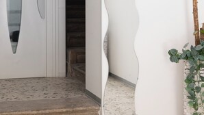 A white door with a glass panel, a curved wall feature, and a staircase leading inside. - Room 2 A (Trapani)