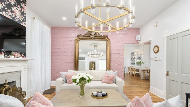 A living room with a white sofa, a coffee table, and a large mirror. - Luxury Rose Manor - Perfect for Bachelorettes! (Columbus)