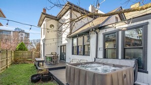 A backyard with a hot tub, wooden deck, and outdoor seating area. - Short North Clubhouse w/Hot Tub! Free Parking! (Columbus)