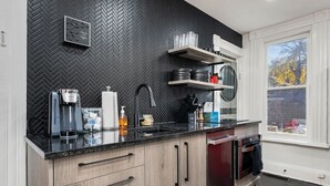 Een moderne keuken met een zwart ruitpatroon achterwand, houten kastjes en een inbouwoven.