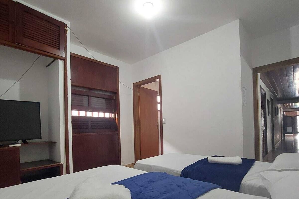 Een hotelkamer met twee bedden, een televisie en een kledingkast.