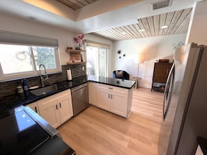 A modern kitchen with a central island, a built-in oven, and a refrigerator.