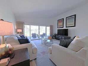 A living room with two sofas, a coffee table, a TV, and a lamp.
