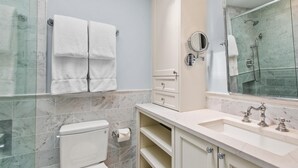 Un baño con inodoro, lavamanos, ducha y espejo.