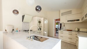 A modern kitchen with a central island, stainless steel appliances, and pendant lighting.