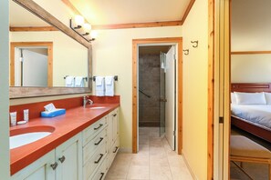 A hotel bathroom with a red sink, a large mirror, and a shower area. - Wildflower Retreat with Resort Access | Pool, Golf, and More! (Sun Valley)
