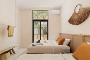 Enjoy a peaceful retreat with a single bed, bedside table, and bench, surrounded by a large window offering a view of the outdoors.