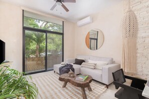 Relax in this serene living space with a large sliding door leading to an outdoor area, a comfortable sofa, and a coffee table.